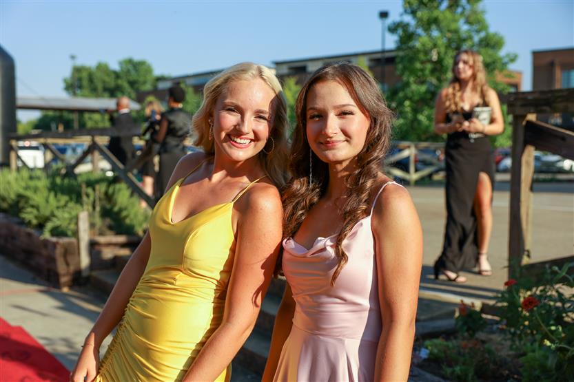 Two young women stand together and smile